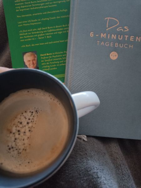 Kaffee, Journal und aktuelles Buch